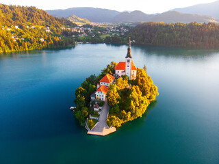 Aerial view of beautiful Lake Bled in the middle of the charming little island and the wonderful church at summer sunrise