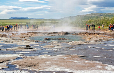 GEYSIR, ICELAND: Moment after an eruption of Strokkur geyser, observed by many tourists, on a day with remarkable cloudscape. 