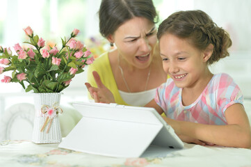 Mother and daughter using tablet together at home