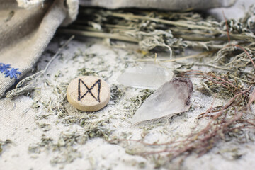 Scandinavian wooden rune Dagaz, Daeg on a rough linen cloth with amethyst crystalline, rock crystal...