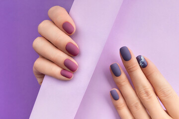 Mooie paarse bordeauxrode matte manicure op creatieve achtergrond