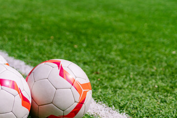 Fototapeta na wymiar Football balls on a pich. Soccer background with copy space.