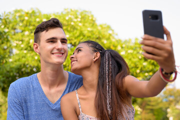Portrait of young multi ethnic couple relaxing together at the park