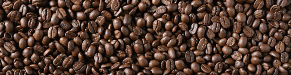 Roasted arabica coffee beans background on wooden table.Arabica coffee is the world's most popular type of coffee.