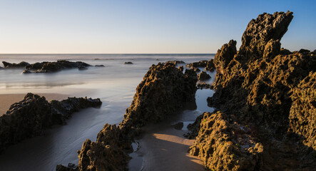 Fototapeta na wymiar Rocks illuminated by the sun on the beach