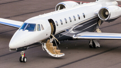 Business jet on the tarmac of an airport with open airstairs © VanderWolf Images