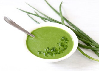 Green onion soup puree in a bowl on a white background