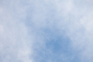 Close-up clear blue sky with transparent white clouds on a summer day, ozone layer pollution, background for wallpaper or banner.