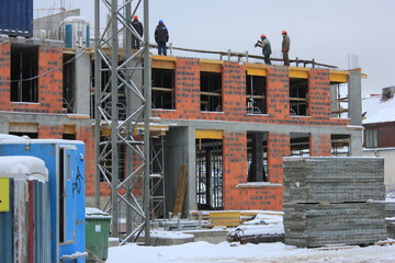 Workers are working on the roof of new building in winter 