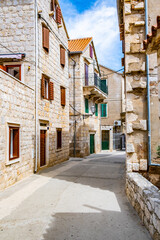 Fototapeta na wymiar Komiza, Vis, Croatia, streets of Komiza town, Old stone houses in a charming narrow alley, typical Mediterranean architecture.