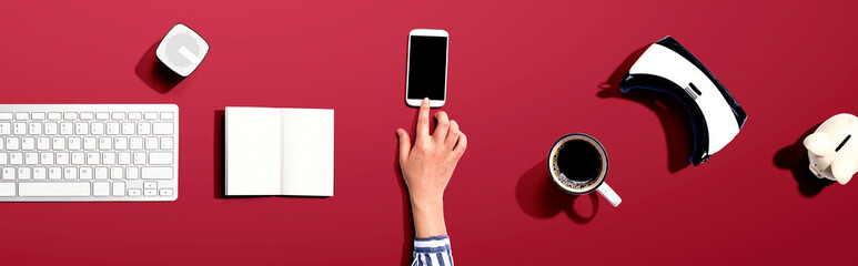 Person using a smartphone with a VR and a computer keyboard