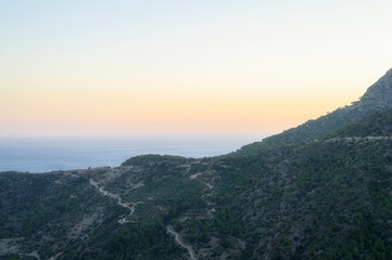 dusk mountain landscape with views of the Mediterranean sea and cloudless sky. Golden hour, haze or fog