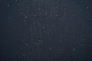 Raindrops running down the glass, evening.