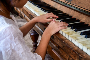 Fototapeta premium Hands of girl kid playing piano. Selective focus