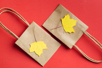 small paper bags with paper craft maple leaves autumn sale concept 