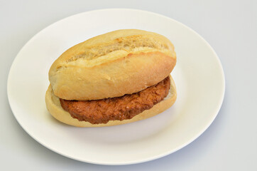 Hamburger in Bun on white Plate,  close up on white Background