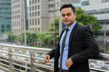 Young handsome Indian businessman in the city