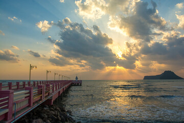 Obraz premium Beautiful blazing sunrises landscape with cloud and sun rays at Ao Prachuap bay with Saranwithi bridge stretching in to the sea Prachuap khiri khan province, Thailand. Public domain