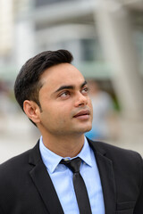 Fototapeta premium Young handsome Indian businessman in the city