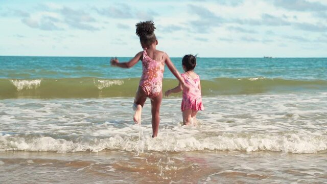 slow motion,Both African American and Asian girls are playing in the water without racism.
