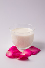 Fresh milk and pink rose petals. Copy area Top view