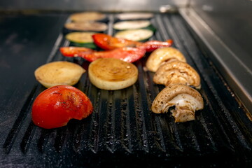 Cooking vegetables grill on the frying surface in black.