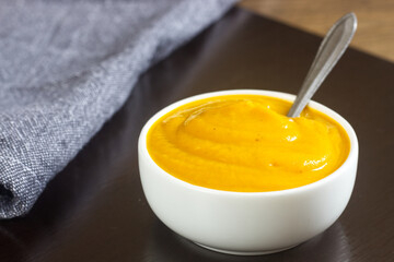Healthy Carrot soup in a white bowl.