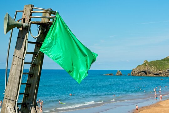 green flag on spanish beach next to the beach lookout post