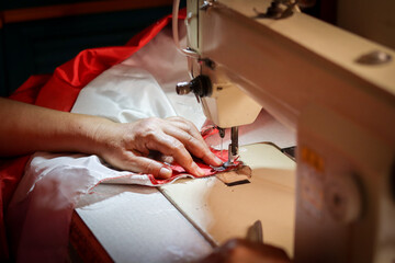 The hand that was stitching an old Indonesian flag to commemorate Indonesia's independence day