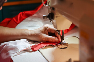 The hand that was stitching an old Indonesian flag to commemorate Indonesia's independence day
