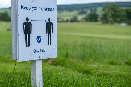 A Sign In A Field Asking People To Socially Distance And Stay Safe At An Outdoor Event As The Coronavirus Lockdown Eases In England