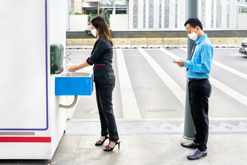 Two business people queuing to wash their hands