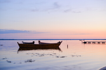 Sunrise on the lake - wooden boat on the lake