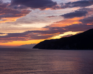 sunset over the italian coast with mountains on the horizon