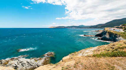 Fototapeta na wymiar View at mediterranean coastline with transparent sea and small beach town at summer