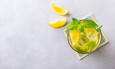 Lemonade, lemon, mint cocktail in glasses. Grey background. Copy space. Top view.