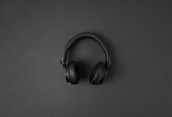 Fototapeta na wymiar Black wireless headphones isolated on abstract dark background