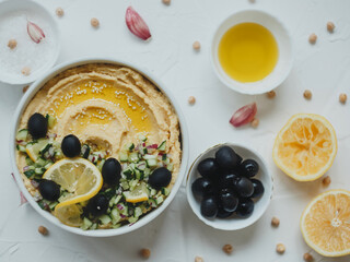 Hummus with olive oil, olives, lemon, garlic, sesame seeds, onions and cucumbers.