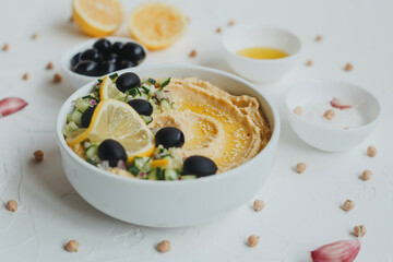 Hummus with olive oil, olives, lemon, garlic, sesame seeds, onions and cucumbers.