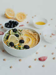 Hummus with olive oil, olives, lemon, garlic, sesame seeds, onions and cucumbers.