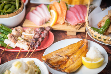 Fototapeta na wymiar traditional japanese izakaya style foods on wooden table