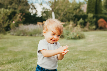 Close-up of baby girl clapping hands in garden