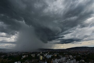 Heavy rain together over Zurich Switzerland with gray storm clouds and blue sky