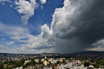 Heavy rain together over Zurich Switzerland with gray storm clouds and blue sky