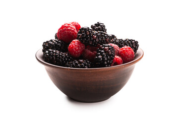 Raspberry, blackberry and mint leaf in ceramic brown bowl isolated on white