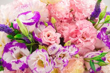 Pink and purple bouquet of flowers in a pink box isolated on white.