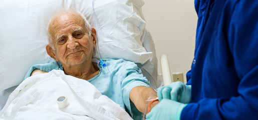 Senior 80 plus year old man recovering from surgery in a hospital bed