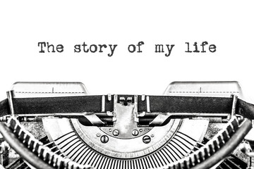 The story of my life is typed on a blank sheet of paper with an old typewriter. Close-up
