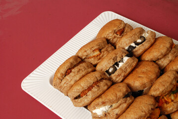 A set of decorated arabian traditional meal olive cheese brown sandwiches in white trey and red background using soft focus selective focus