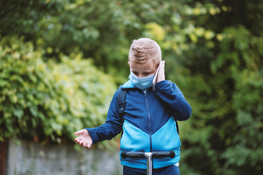 Little 8 Year Old Boy , Wearing Protective Mask And Talking On His Cellphone.